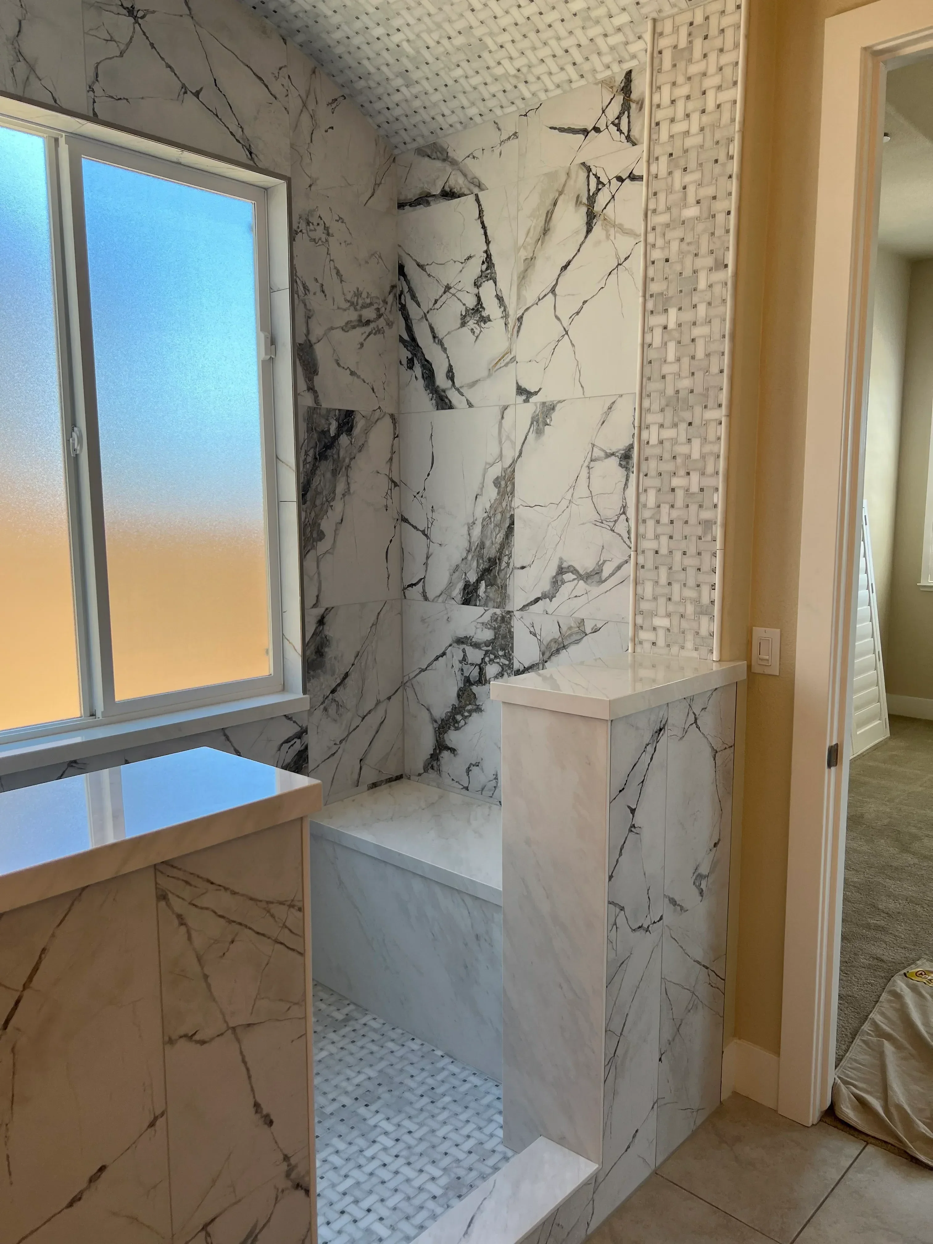 Large-format marble floor tiles with black veining installed in kitchen with matching backsplash