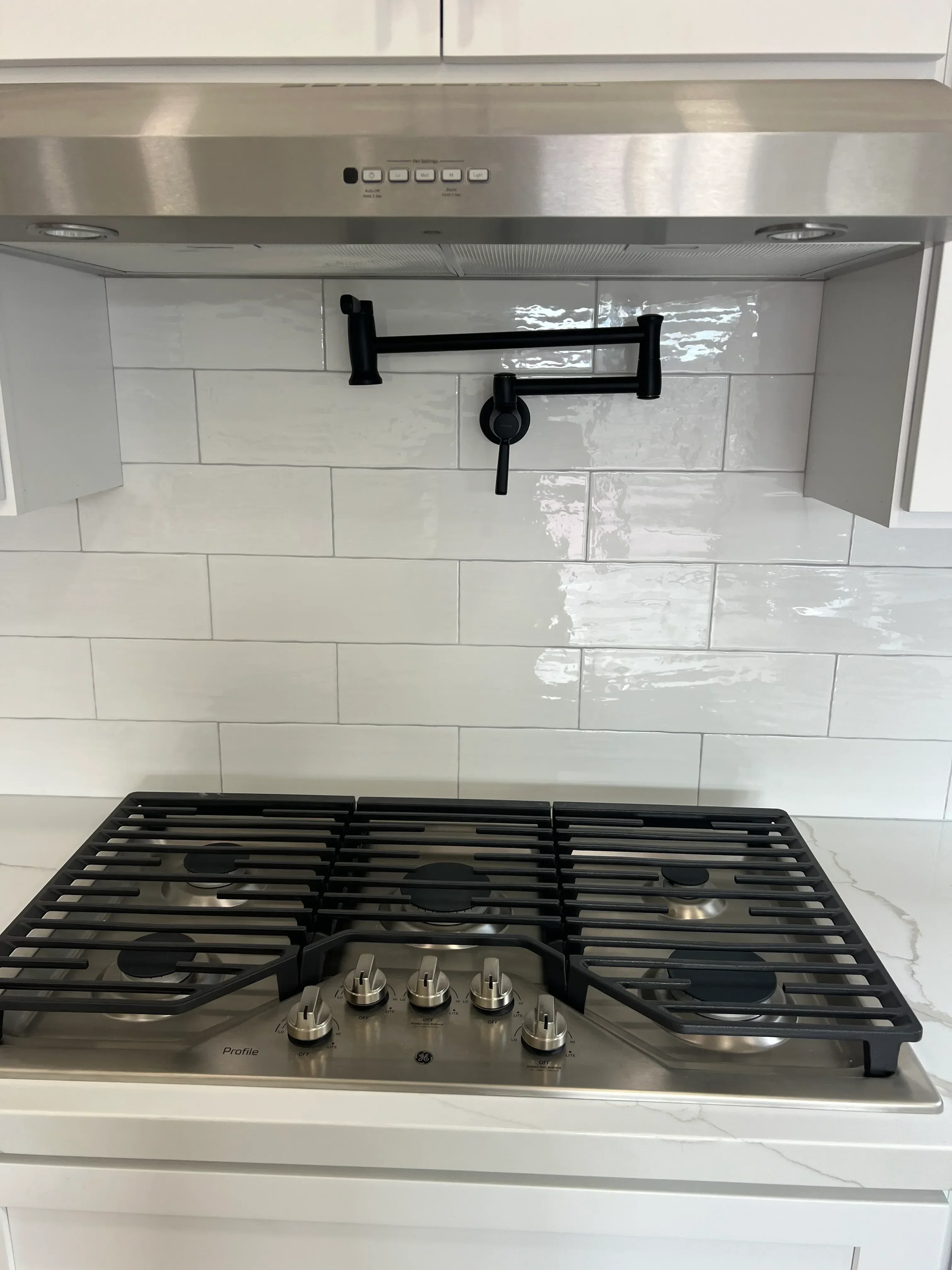 Frameless glass shower with white subway tile, black hardware, and multi-spray fixture system