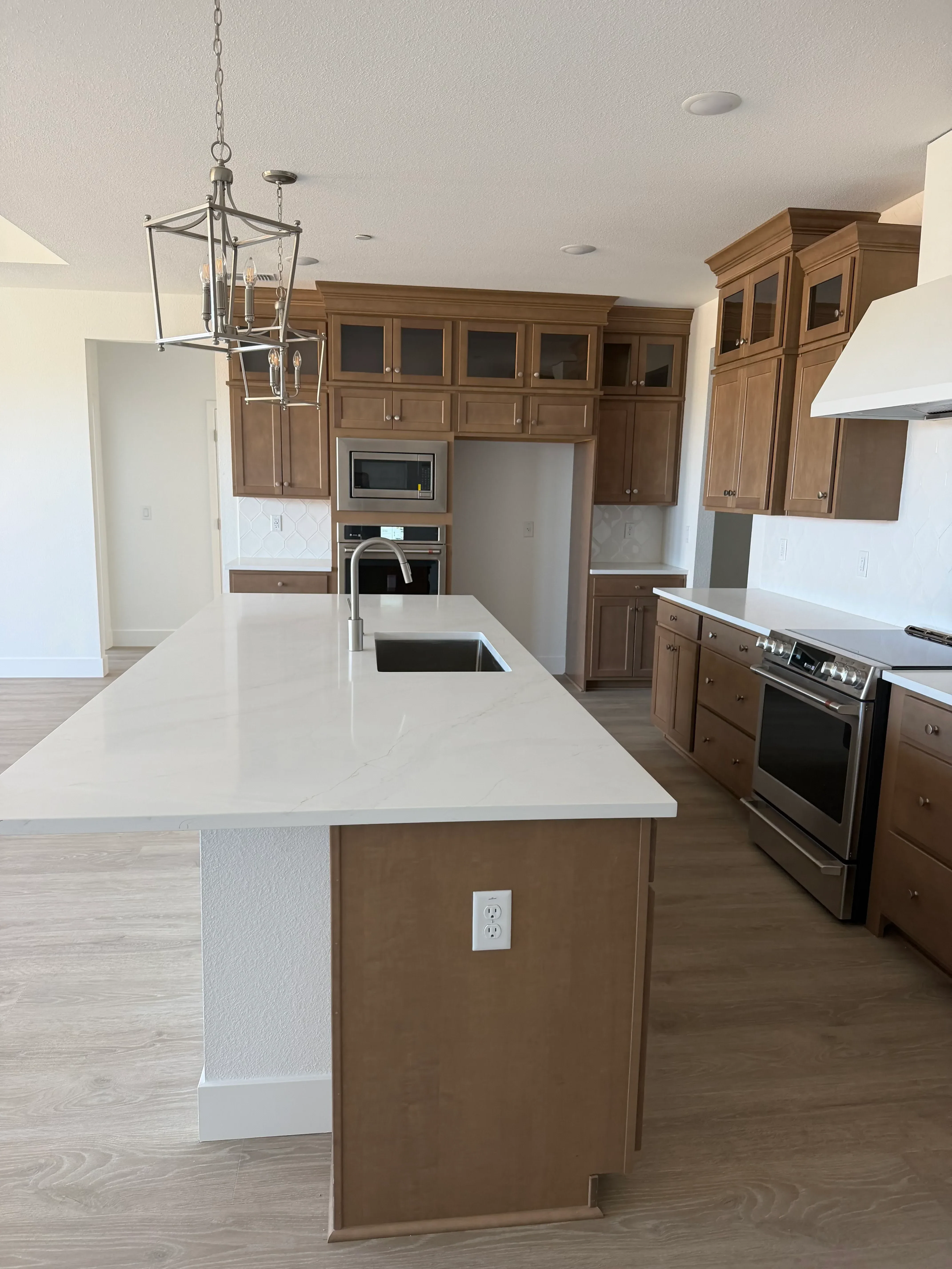 Kitchen remodel with wood cabinetry, stainless steel appliances, white countertops, and recessed lighting