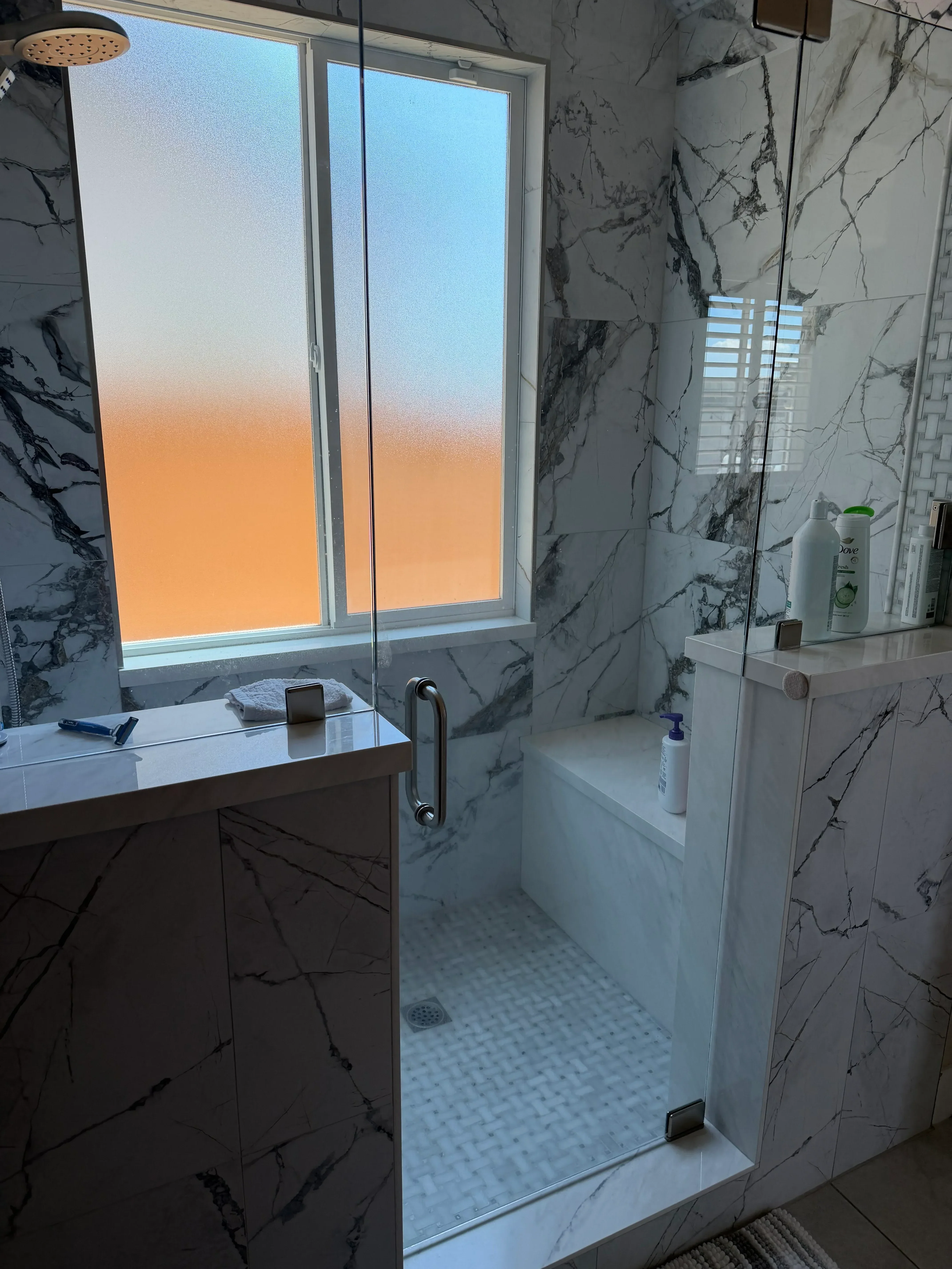 Marble tile bathroom with black veining, white subway tile shower, chrome fixtures