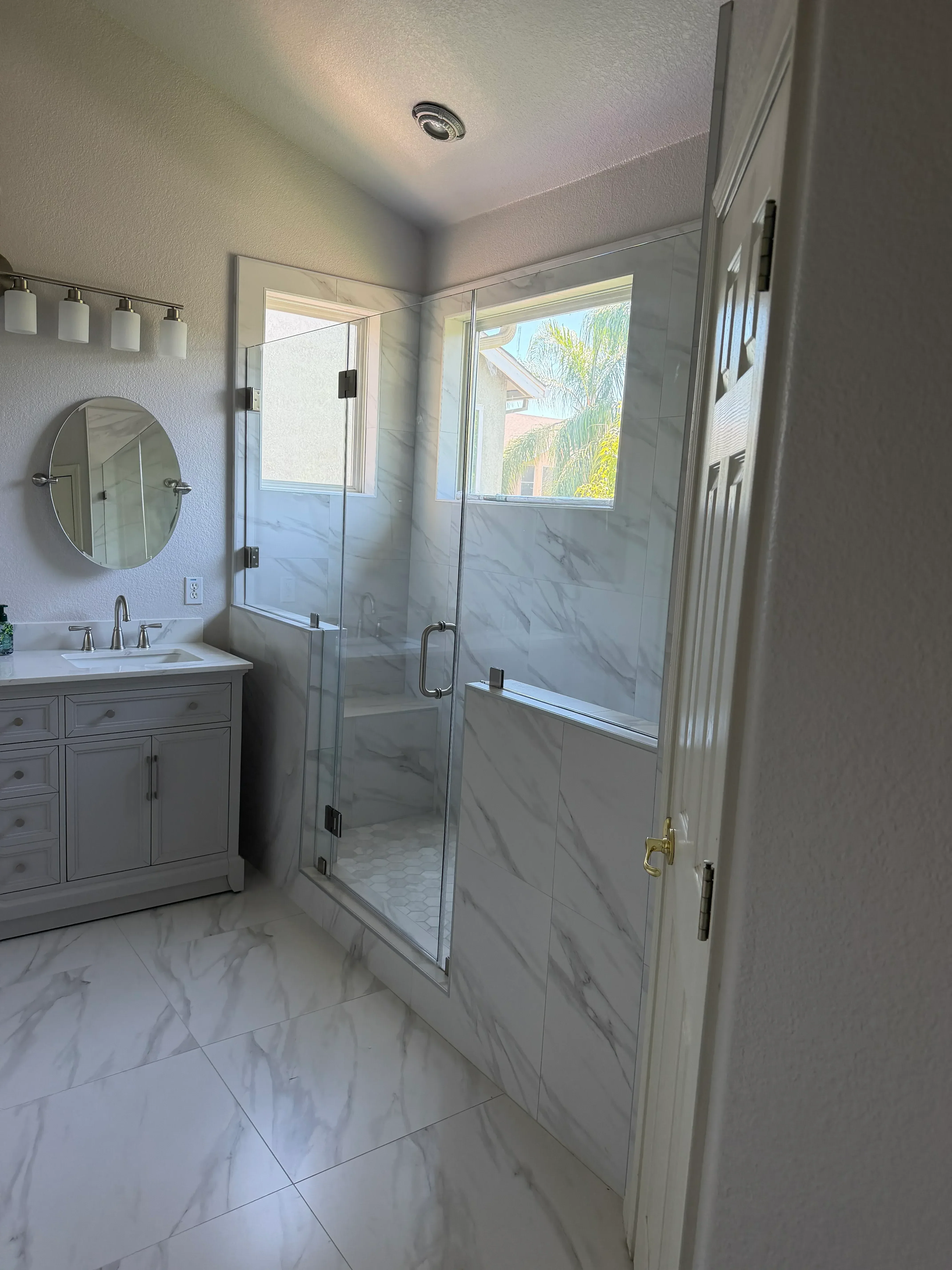 Marble tile bathroom with skylight windows, vanity sink, and chrome fixtures
