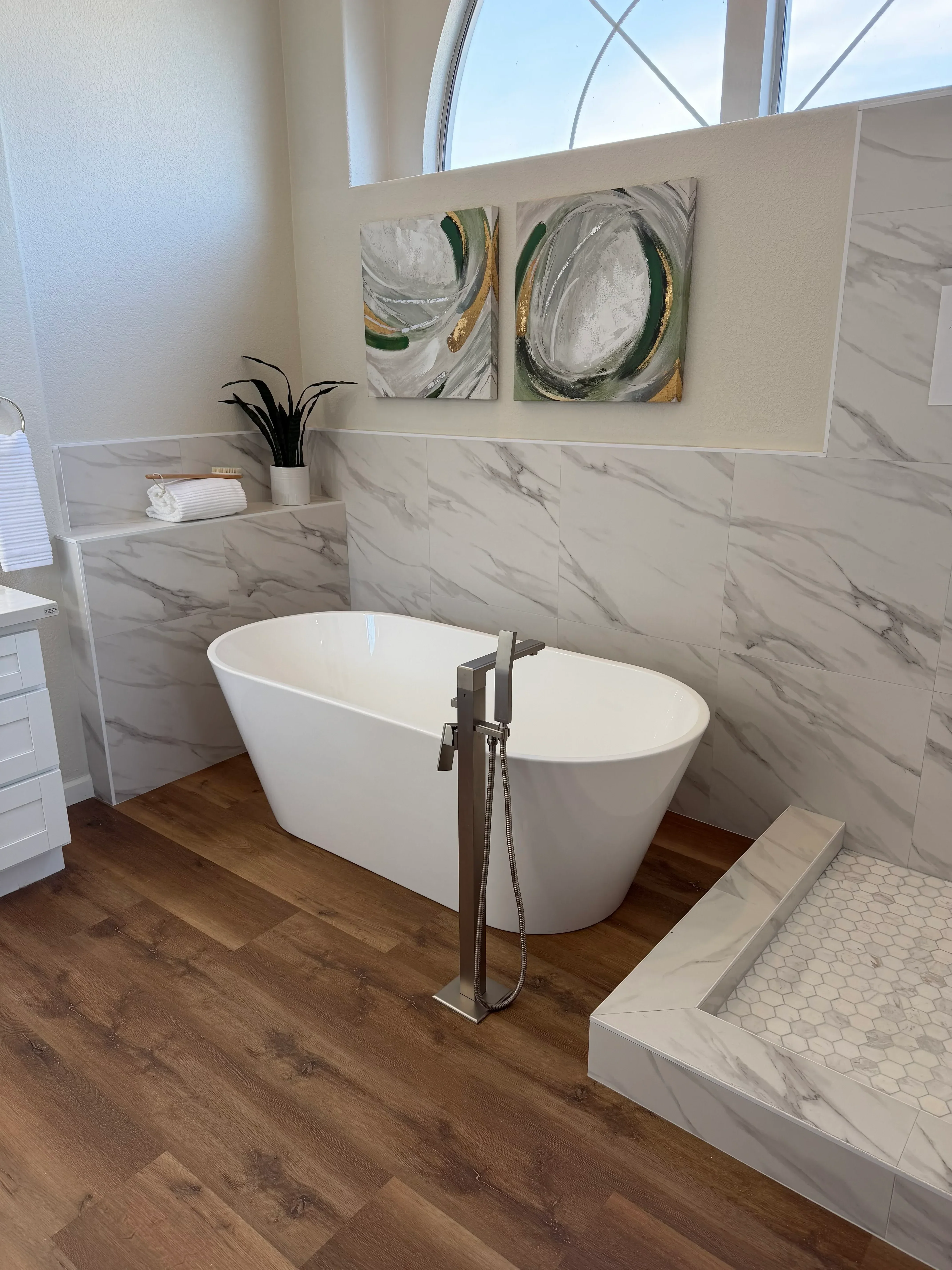 Marble tile bathroom with white toilet, chrome fixtures, and hexagonal tile accents