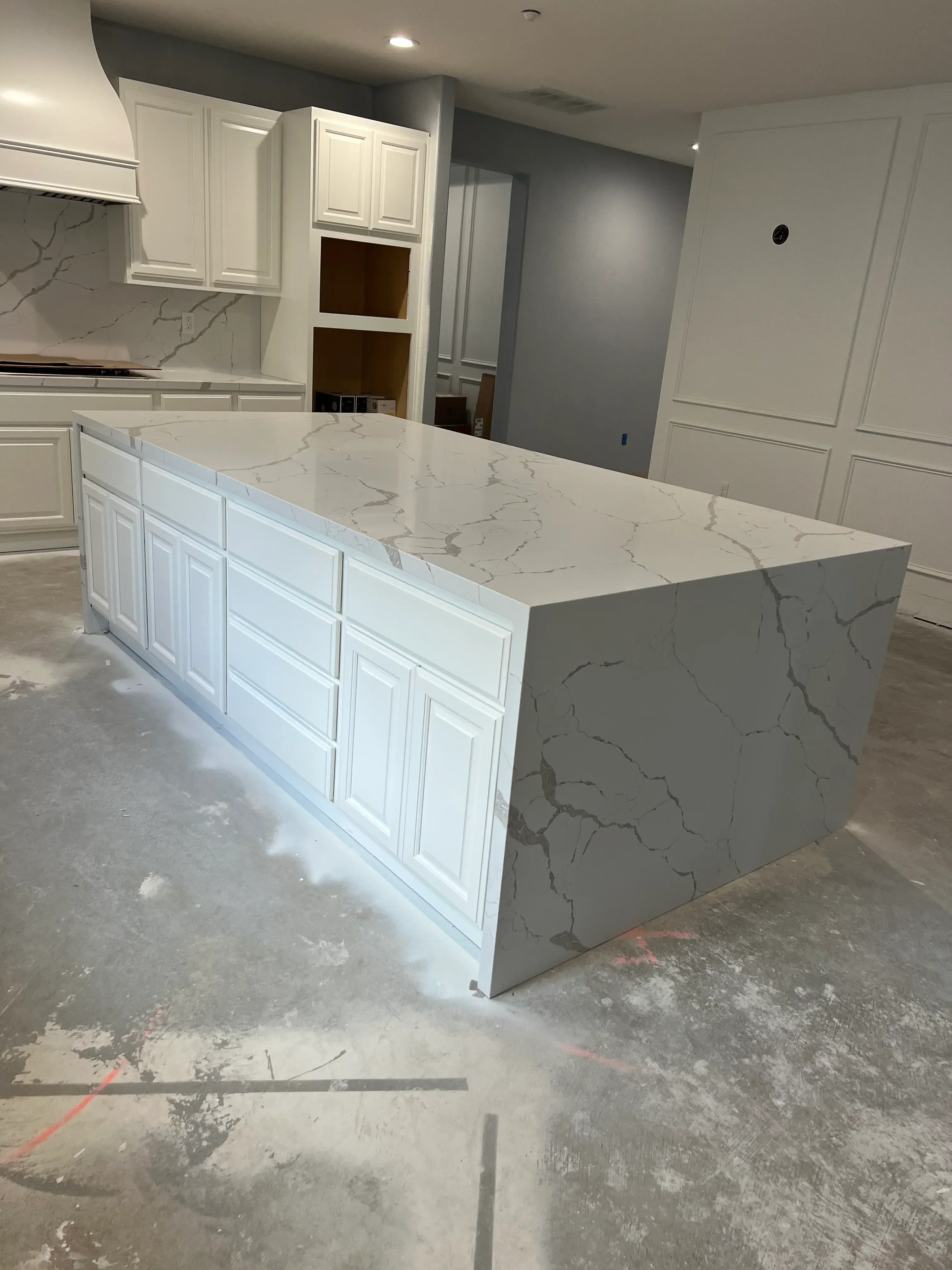 Kitchen remodel with white cabinetry, gray quartz countertops, and coffered ceiling installation